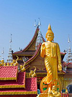 Фигура Будды на фоне буддийского дворца в Сишуанбаньна, Китай