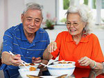 Chinese adult couple having traditional family dinner