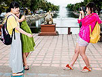 Tourists posing against the backdrop of local attractions, China