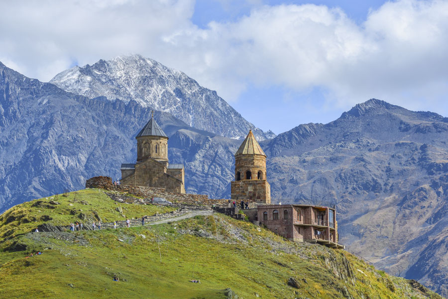 , Best Time to Visit Georgia: Gergeti Trinity Church near Stepantsminda in Summer